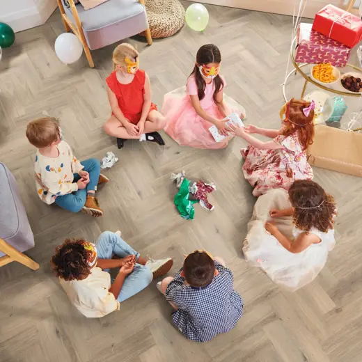 Van Gogh Canadiuan Urban Oak herringbone mid brown LVT flooring with children sat down